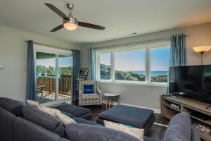 a living room with a couch and a flat screen tv at Castaway in Caswell Beach