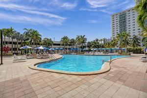 a swimming pool with chairs and umbrellas in a resort at Ocean Reserve Condominium in Miami Beach