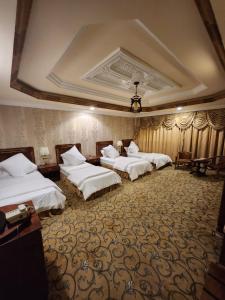 a hotel room with three beds in a room at فندق شموخ السعد in Mecca +10 photos