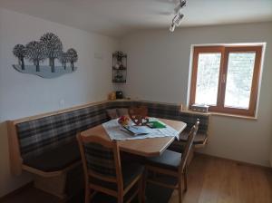 ein Esszimmer mit einem Tisch, Stühlen und einem Fenster in der Unterkunft Gästehaus Braunegger in Oetz