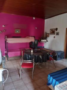 Habitación con cama, mesa y sillas. en Hostel Monte Grande en Monte Grande
