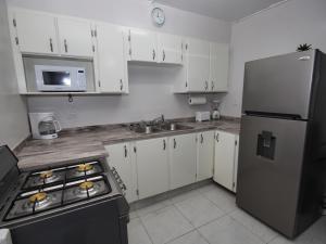 a kitchen with white cabinets and a stainless steel refrigerator at The Castle in Philipsburg
