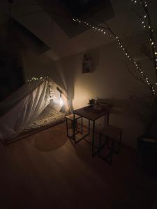 Habitación con cama, mesa y luces. en Le Nid Douillet en Plancher-Bas