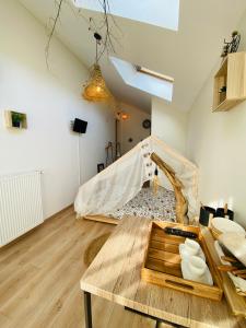 a living room with a wooden table in a room at Le Nid Douillet in Plancher-Bas
