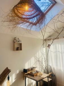 a room with a table and a ceiling with a window at Le Nid Douillet in Plancher-Bas +9 photos