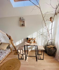 Le Nid Douillet في Plancher-Bas: غرفة مع طاولة وكراسي في غرفة