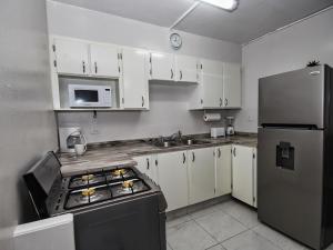 a kitchen with white cabinets and a stainless steel refrigerator at The Castle in Philipsburg