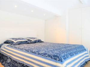 sypialnia z łóżkiem z niebieską kołdrą i poduszkami w obiekcie Duplex moderne 5 pers avec terrasse et parking - FR-1-251-456 w mieście Le Lavandou