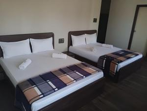 dos camas sentadas una al lado de la otra en una habitación en HONNASIRI RESIDENCY, en Shimoga