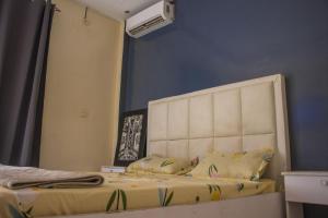 uma cama com uma cabeceira branca num quarto em DALOU Chambre hôte, Cité mixta em Dakar