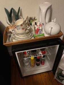 einen kleinen Kühlschrank mit Geschirr und Tellern in der Unterkunft Overijse’s cosiest double room in Overijse