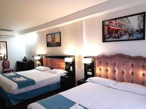 a hotel room with two beds and two lamps at HOTEL ROYAL Paris Ivry in Ivry-sur-Seine