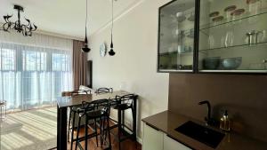 a kitchen with a bar with stools and a sink at Hanza 1107 in Szczecin