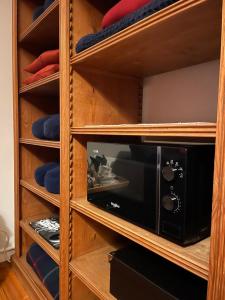 un four micro-ondes dans une armoire en bois dans l'établissement Overijse’s cosiest double room, à Overijse