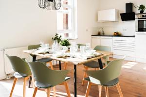 - une salle à manger avec une table et des chaises dans l'établissement 80qm Apartment in Krefeld zentral gelegen mit hohen Decken - BEUYS Apartments - Krefeld, à Krefeld