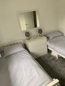 a bedroom with two twin beds and a mirror at Idyllic holiday near Abersoch in Mynytho