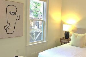 Schlafzimmer mit einem Bett und einem Fenster in der Unterkunft Luxury - Pet Friendly 3bd, 3ba South End Condo in Boston