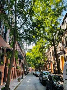 una calle arbolada con coches y edificios estacionados en Luxury - Pet Friendly 3bd, 3ba South End Condo en Boston