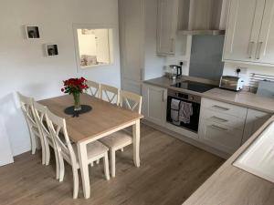 a kitchen with a wooden table with a vase of flowers on it at Idyllic holiday near Abersoch in Mynytho