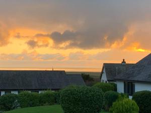 a group of houses with a sunset in the background at Idyllic holiday near Abersoch in Mynytho