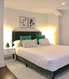 a bedroom with a large bed with green pillows at Luxury - Pet Friendly 3bd, 3ba South End Condo in Boston