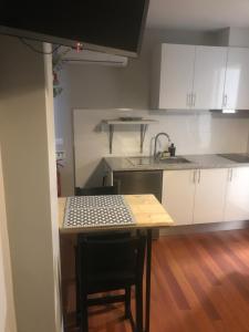 a kitchen with white cabinets and a table and a sink at Ilha 12 Suites in Coimbra