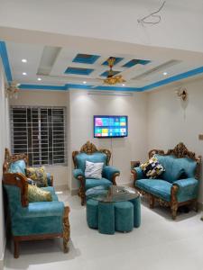 uma sala de estar com cadeiras azuis e uma mesa em Stunning 1-Bed Apartment in Dhaka close to airport em Daca