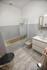 a bathroom with a tub and a toilet and a sink at Eden Auberge in Villefranche-du-Périgord