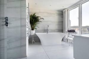 a bathroom with a white tub and a sink at Luxury Panoramic 3 bed with private terrace in London