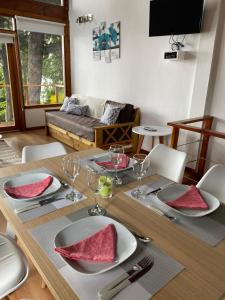a dining room table with plates and wine glasses at Bosque al Lago in San Carlos de Bariloche