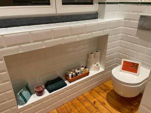 La salle de bains est pourvue de toilettes et d'un mur en briques. dans l'établissement Overijse’s cosiest double room, à Overijse