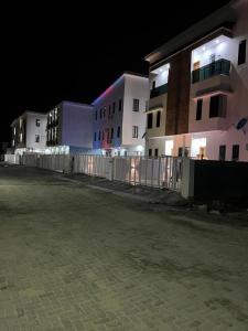 una fila di edifici di notte con luci di Cecilia Homes a Lekki