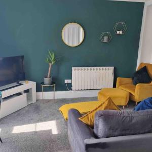 uma sala de estar com um sofá e uma televisão em First floor apartment in Stratton, Bude em Stratton