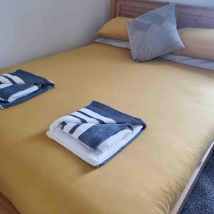 duas camas com toalhas em cima em First floor apartment in Stratton, Bude em Stratton