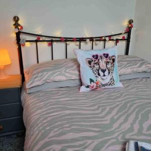 ein Bett mit einem Gepard-Kissen darauf in der Unterkunft First floor apartment in Stratton, Bude in Stratton