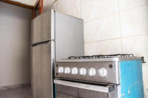 達喀爾的住宿－DALOU Chambre hôte, Cité mixta，厨房配有炉灶和冰箱。
