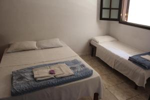 a room with two beds with towels on them at Hotel Nossa Senhora da Conceição in Sabará