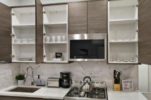una cocina con fregadero y estufa horno superior en Comfortable & Furnished Studio Apt with Wi-Fi - Magnolia CH, en Chicago