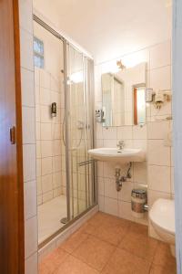 een badkamer met douche, wastafel en toilet bij Strandhotel Pichler in Seeboden