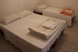 two beds with towels on top of them in a room at Hotel Nossa Senhora da Conceição in Sabará
