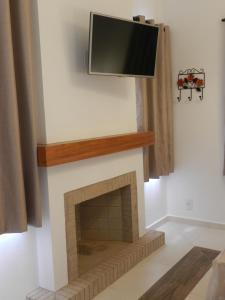 a fireplace with a flat screen tv above it at Hotel Villa Greenberg in Monte Verde