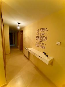 un pasillo con una pared amarilla con una escritura en la pared en TuristHome Greco, en Sarria