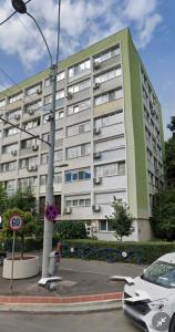 un grande edificio con un'auto parcheggiata di fronte di Bright House Cantemir a Bucarest