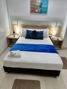 ein Schlafzimmer mit einem großen Bett mit blauer Bettwäsche und Kissen in der Unterkunft Hotel Boutique Deluxe in Santa Marta