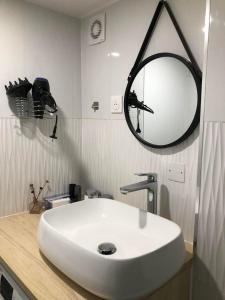 y baño con lavabo blanco y espejo. en F2 équipé, 15mn de Paris, parking, climatisation, en Bourg-la-Reine