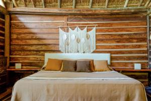 Cama en habitación con paredes de madera en Madre Tierra Eco Habitat en Puerto Morelos