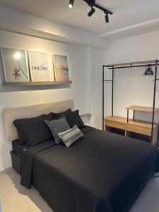 um quarto com uma cama preta e um espelho em Studio Felicittá piscina cozinha academia em Juiz de Fora