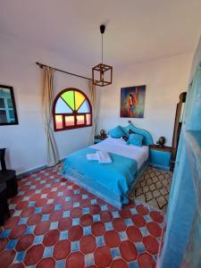 a bedroom with a blue bed and a window at Les Villas de Nouran 7chambres in Ghazoua +22 photos