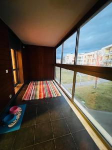 Habitación con ventanas grandes y vistas a la calle. en Coqueto apartamento en Las margas golf, en Sabiñánigo