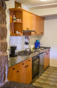 a kitchen with wooden cabinets and a stove top oven at Galicia in Forcarei